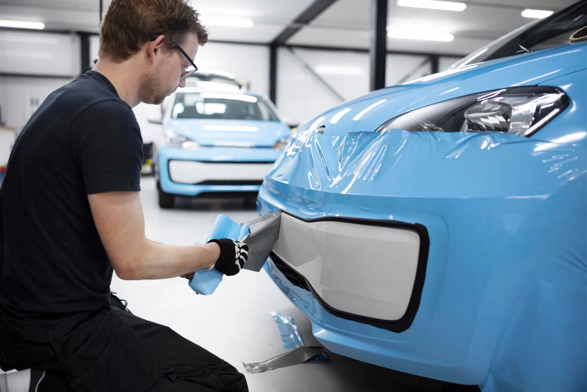 Car being carefully detailed in a clean workshop